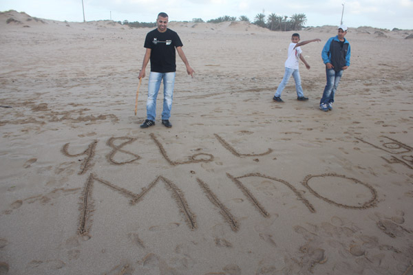  الشاب وسام الزبارقة يكتب اسم موقع يافا 48 على شاطئ البحر 